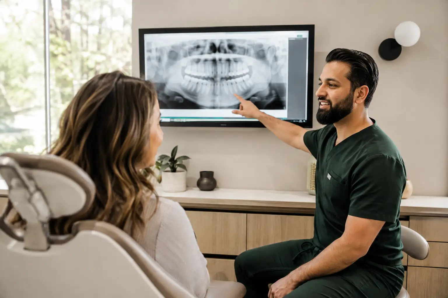 Dentist explaining a dental X-ray and treatment options to a patient in Cold Lake.
